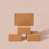 Four cork yoga blocks stacked on a beige background